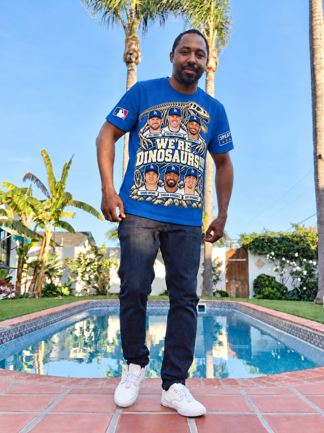 Gregory beside a pool, modeling the Dodger Blue We're Dinosaurs!!!! six-player shirt in a photo-based clothing mockup